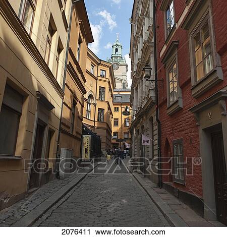 Pedestrians Walking Down A Narrow Street In Between Buildings; Stockholm Sweden View Large Photo Image Stock Image - Pedestrians Walking Down A Narrow Street In Between Buildings; Stockholm Sweden. Fotosearch