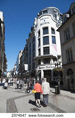 Pedestrians walking down a narrow street between retail buildings; Luxembourg View Large Photo Image Stock Photo - Pedestrians walking down a narrow street between retail buildings; Luxembourg. Fotosearch