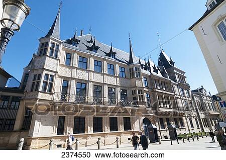 Stock Image - Pedestrians walking on a pathway by an building with spires; Luxembourg. Fotosearch