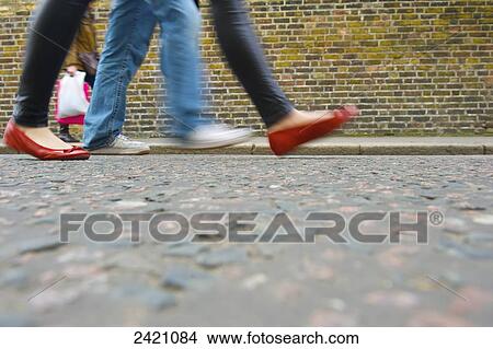 Pedestrians walking on a sidewalk of Portobello Road beside a brick building; London, England View Large Photo Image Picture - Pedestrians walking on a sidewalk of Portobello Road beside a brick building; London, England. Fotosearch