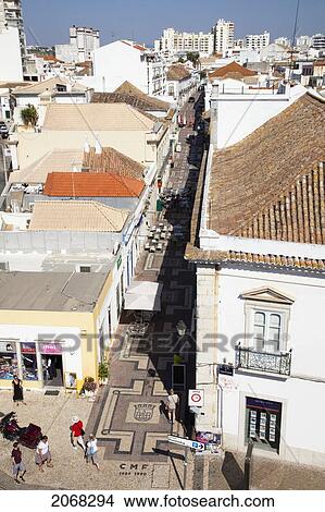 Picture - Pedestrians Walking On A Street Between The Buildings; Faro Algarve Portugal. Fotosearch