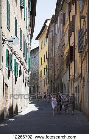 Pedestrians walking on a street in-between residential buildings; Montepulciano, Val D'Orcia, Tuscany, Italy View Large Photo Image Stock Image - Pedestrians walking on a street in-between residential buildings; Montepulciano, Val D'Orcia, Tuscany, Italy. Fotosearch