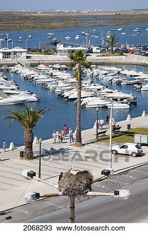 Stock Image - Pedestrians Walking On The Promenade Along The Harbour; Faro Algarve Portugal. Fotosearch