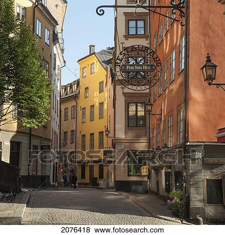 Stock Photo - Pedestrians Walking On The Street Beside Colourful Painted Buildings; Stockholm Sweden. Fotosearch
