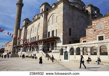 Stock Image - Pedestrians walking outside an Islamic mosque; Istanbul, Turkey. Fotosearch