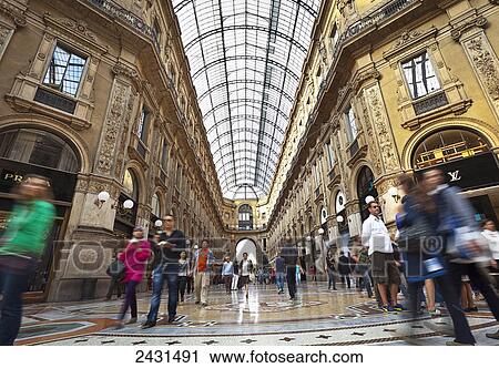 Pedestrians walking under a domed glass ceiling between buildings; Milano, Italy View Large Photo Image Stock Image - Pedestrians walking under a domed glass ceiling between buildings; Milano, Italy. Fotosearch