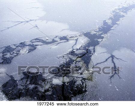 Stock Photography - Pele In Ice, Rhode Island, Warren, Winter Snow Falling On Cracks In Ice-Covered Water.. Fotosearch