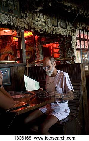 Stock Photo - Pensacola, Florida, Usa; Senior Male Looking At Restaurant Menu. Fotosearch