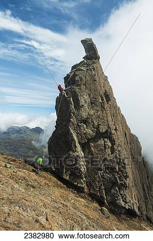 Stock Image - People abseil off the Inaccessible Pinnacle at the summit of Sgurr Dearg; Isle of Skye, Scotland. Fotosearch
