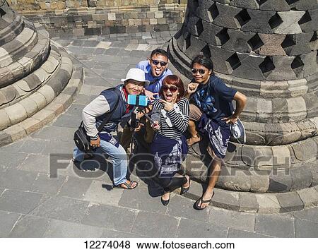 People amidst the latticed stone stupas containing Buddha statues on the upper terrace, Borobudur Temple Compounds, Central Java, Indonesia View Large Photo Image Stock Photo - People amidst the latticed stone stupas containing Buddha statues on the upper terrace, Borobudur Temple Compounds, Central Java, Indonesia. Fotosearch