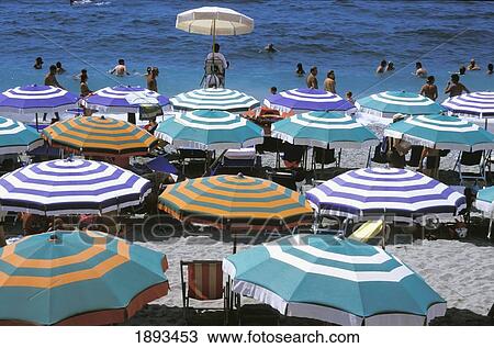 Stock Image - People And Umbrellas At Monterosso Beach. Fotosearch