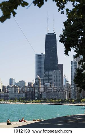 Stock Photo - People Basking On Oak Street Beach With High Rise Buildings In Background, Chicago, Illinois, Usa. Fotosearch