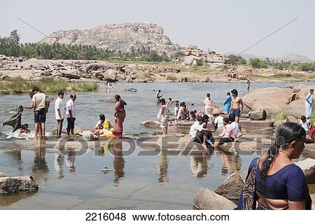 People Bathing Along The Tungabhadra River In Hampi. Hanuman Temple On Top Of Anjaneya Hill In Background, Karnataka, India View Large Photo Image Stock Photo - People Bathing Along The Tungabhadra River In Hampi. Hanuman Temple On Top Of Anjaneya Hill In Background, Karnataka, India. Fotosearch