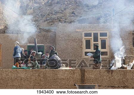 Stock Image - People By A Samovar On A House By The Entrance Of The Pai Mori Gorge, Bamian Province, Afghanistan. Fotosearch