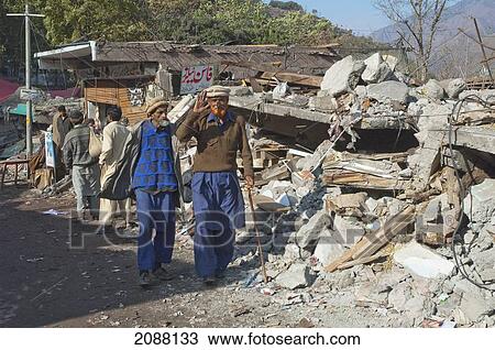 Stock Image - People By The Bazaar Destroyed By The 8 October 2005 Earthquake, Chinari, Azad Kashmir, Pakistan. Fotosearch