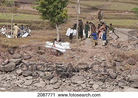 People Carrying Bails On A Ropeway Over The Jhelum River After The 8 October 2005 Earthquake, Subri, Azad Kashmir, Pakistan View Large Photo Image Stock Image - People Carrying Bails On A Ropeway Over The Jhelum River After The 8 October 2005 Earthquake, Subri, Azad Kashmir, Pakistan. Fotosearch
