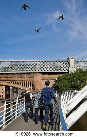 People crossing footbridge over canal, Castlefield, Manchester, England View Large Photo Image Stock Photograph - People crossing footbridge over canal, Castlefield, Manchester, England. Fotosearch