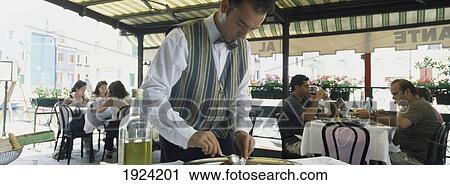 Stock Image - People Eating At Tables In Restaurant.. Fotosearch