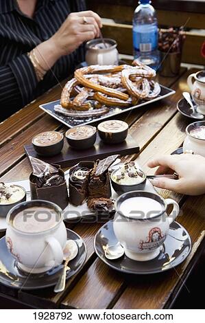 Stock Image - People Eating Cakes With Coffee In Cafe, Close-Up, Fitzroy/Brunswick Street Areas, Melbourne, Australia. Fotosearch
