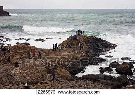 Stock Image - People exploring the natural wonders of Giant's Causeway; County Antrim, Ireland. Fotosearch