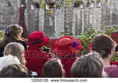Stock Photography - People gather at the Tower of London to see the almost 900, 000 ceramic poppies commemorating the UK and Commenwealth war dead of World War One which had the 100th anniversary of the start of the war in 2014; London, England. Fotosearch