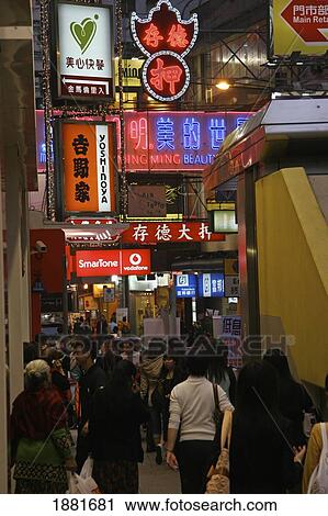 Stock Image - People In Busy Street With Neon Signs In Tsim Sha Tsui. Fotosearch