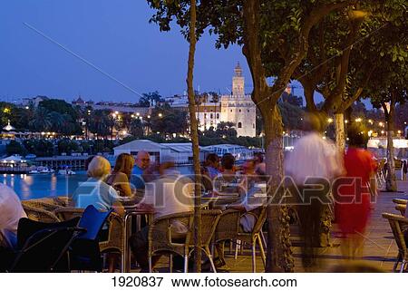 Stock Photo - People In Outdoor Restaurant At Dusk. Fotosearch