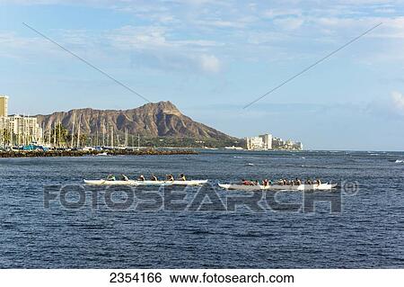 Stock Photograph - People in outrigger canoes with Diamond Head crater in the background; Oahu, Hawaii, United States of America. Fotosearch