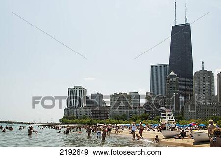Stock Photo - People In The Water And On The Beach With Skyscrapers In The Background; Chicago Illinois United States Of America. Fotosearch