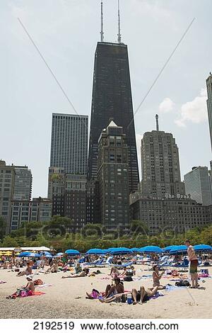 Stock Photo - People Laying On The Beach With Skyscrapers In The Background; Chicago Illinois United States Of America. Fotosearch