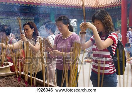 Stock Photograph - People Lighting Up Incense Sticks. Fotosearch