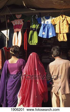 Stock Image - People Looking At Children's Clothing Stall, Chirawa, Shekhawati, Rajasthan, India.. Fotosearch