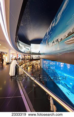 Stock Photo - People Looking In Large Window, Dubai Mall Aquarium; Dubai, United Arab Emirates. Fotosearch