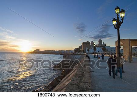 Stock Photo - People On Promenade At Sunset. Fotosearch