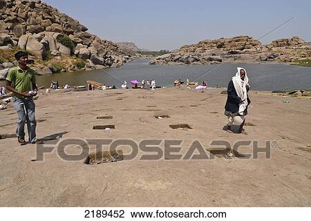 People On The Ancient Ghats On The Tungabhadra River In Hampi With Hanuman Temple In Background View Large Photo Image Stock Image - People On The Ancient Ghats On The Tungabhadra River In Hampi With Hanuman Temple In Background. Fotosearch