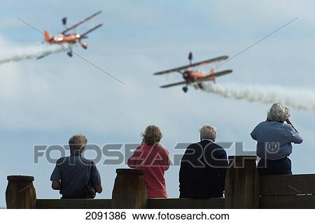 People On The Seafront Watching The Breitlng Wing Walkers In Action At The Eastbourne Airshow, East Sussex, Uk View Large Photo Image Stock Photograph - People On The Seafront Watching The Breitlng Wing Walkers In Action At The Eastbourne Airshow, East Sussex, Uk. Fotosearch