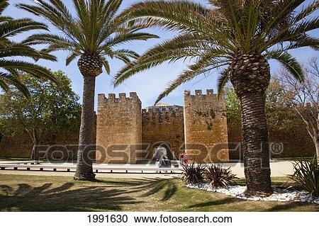 Stock Image - People Outside A City Wall; Lagos Algarve Portugal. Fotosearch
