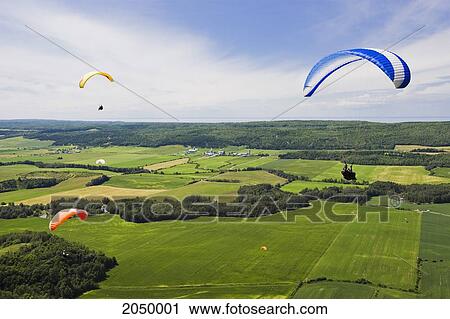 Stock Image - People Paragliding Over Fields, Bas-Saint-Laurent Region, Saint-Anaclet, Quebec. Fotosearch