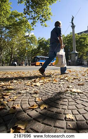 Stock Photograph - People Passing By In Front Of The Liberty Statue By Artist Jose Livi, In Cagancha Square, Montevideo, Uruguay, South America. Fotosearch
