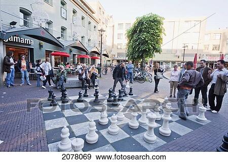 People Playing With A Giant Chess Set On A Square, Amsterdam, Netherlands View Large Photo Image Stock Photo - People Playing With A Giant Chess Set On A Square, Amsterdam, Netherlands. Fotosearch