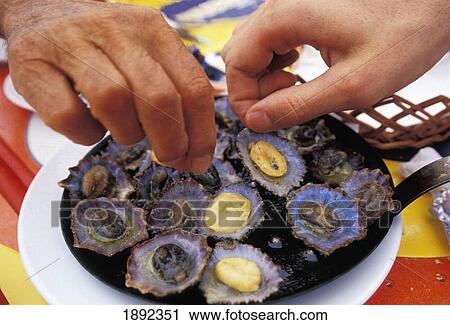 Stock Image - People Reaching For Typical Lunch Of Garlic Limpets, Close Up Of Hands. Fotosearch
