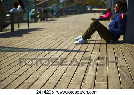 Stock Photography - People relaxed on a wooden promenade; Barcelona, Spain. Fotosearch