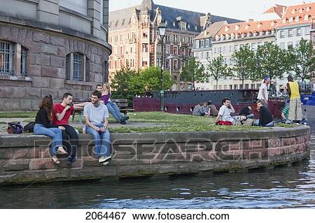 Stock Photo - People Sitting On The Dock Koch By The Ill River, Strasbourg, France. Fotosearch