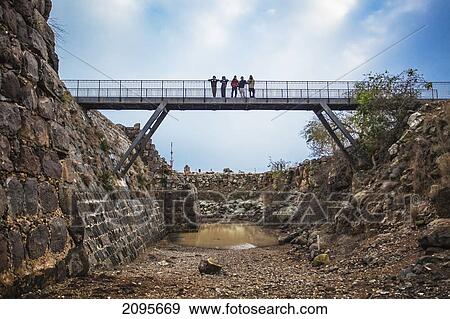 Stock Photo - People Standing On A Bridge Over A Moat In Kokhav Ha Yarden National Park; Israel. Fotosearch
