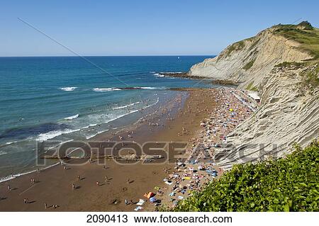 Stock Image - People Sunbathing At Itzurun Beach, Zumaia, Basque Country, Spain. Fotosearch