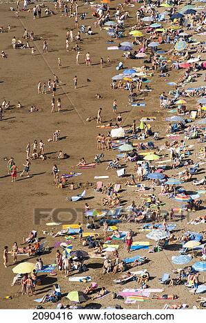 Stock Photograph - People Sunbathing At Itzurun Beach, Zumaia, Basque Country, Spain. Fotosearch
