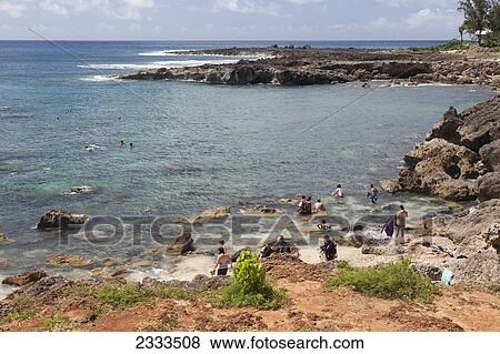 People swimming around the rocks along the rugged coast; Honolulu, Oahu, Hawaii, United States of America View Large Photo Image Stock Photo - People swimming around the rocks along the rugged coast; Honolulu, Oahu, Hawaii, United States of America. Fotosearch