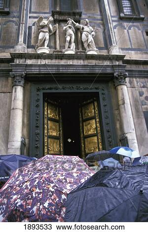Stock Image - People Under Umbrellas Outside Duomo. Fotosearch
