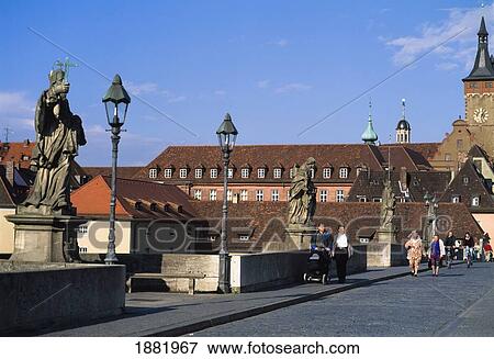 Stock Photo - People Walking Along Alte Mainbrucke Bridge With Stone Statues. Fotosearch