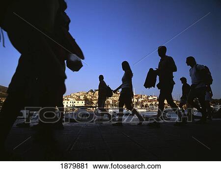 Stock Image - People Walking Along The Harbour-Front Of Hvar Town At Dusk. Fotosearch